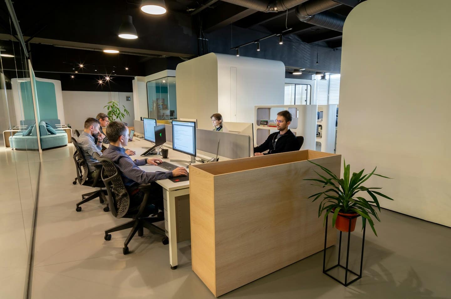 Profesionáli usilovne pracujúci za počítačmi v modernej kancelárii.